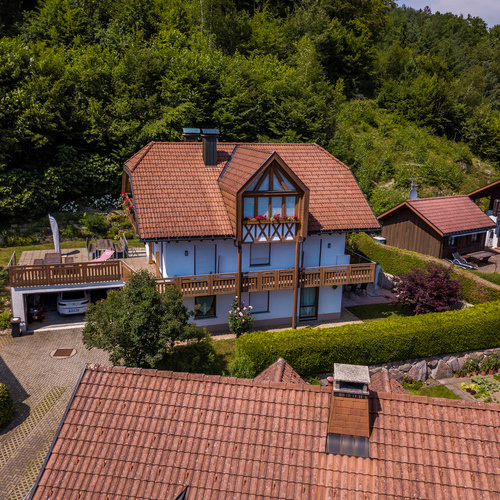 Ansicht Haus - Das Haus liegt in einer ruhigen, dennoch zentralen Wohngegend direkt am Waldrand. Zu Fu&szlig; in 5 Min. zu erreichen sind: das Zentrum, beheiztes Freibad, Minigolf, Restaurants, Supermarkt, Kirche und Bushaltestelle