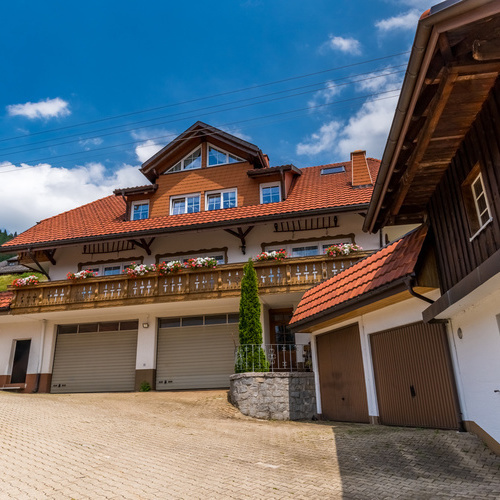 Die R&uuml;ckseite des Hauses mit gepflastertem Hof und Garagen - 