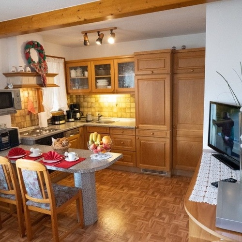 Esstisch und K&uuml;che mit Holzschr&auml;nken - 