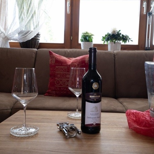 Eine Flasche Wein und zwei Weingl&auml;ser stehen auf dem Couchtisch - 