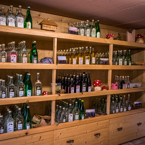 Holzregal mit verschiedenen Schnapsflaschen  - 