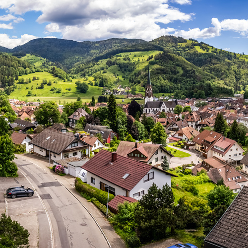 Blick auf Sch&ouml;nau mit den umliegenden gr&uuml;nen W&auml;lder und H&uuml;gel - 